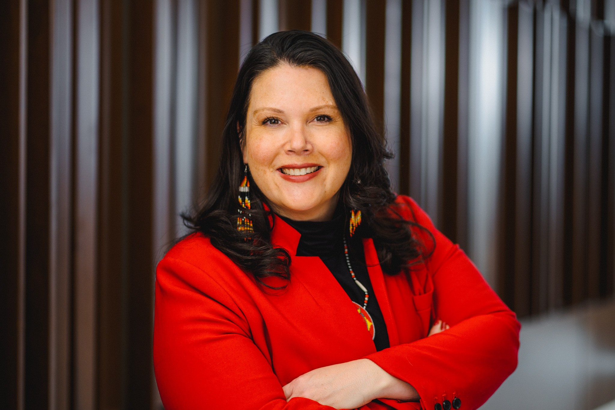 Elizabeth Kronk Warner, a Native woman with white skin and dark-brown hair wearing a red blazer