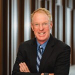 Professor Paul Cassell, a middle-aged white man with red hair wearing a black suit coat and blue collared shirt