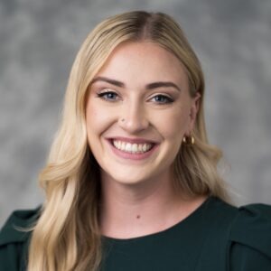 McKaela Dangerfield, a young white woman with long blonde hair and blue eyes wearing a black blouse