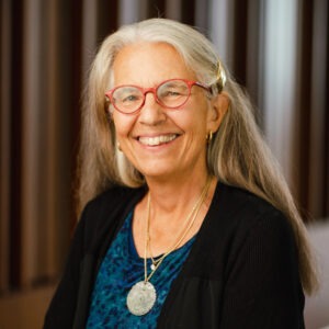 Professor Leslie Francis, an older white woman with long silver hair wearing a silver medallion necklace