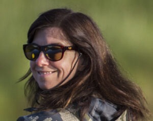 Professor Nancy McLaughlin, a white woman with long dark-brown hair wearing sunglasses